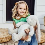 Child holding a large plush bunny.