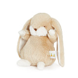 Beige plush bunny toy with a white tag on a white background
