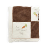 Blanket with brown and white checkered pattern, embroidered carrots, and text on a white background