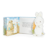 Children's book with illustrations of a dog and a bunny, accompanied by a plush toy on a white background.