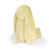 Back view of a yellow plush bunny on a white backgorund.