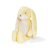 Side view of a yellow plush bunny with embroidered features.