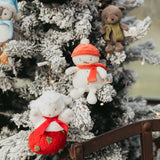 Decorative Christmas tree with plush toys including a snowman, sheep, and teddy bear.