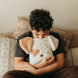 Child hugging a plush dog toy on a couch