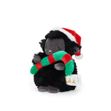 Black plush lamb toy with a Santa hat and Christmas candycane on a white background