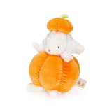 A plush toy featuring a white sheep peeking out from an orange pumpkin-shaped body, with a matching orange pumpkin hat on top. A small fabric tag is visible on the side, set against a plain white background.