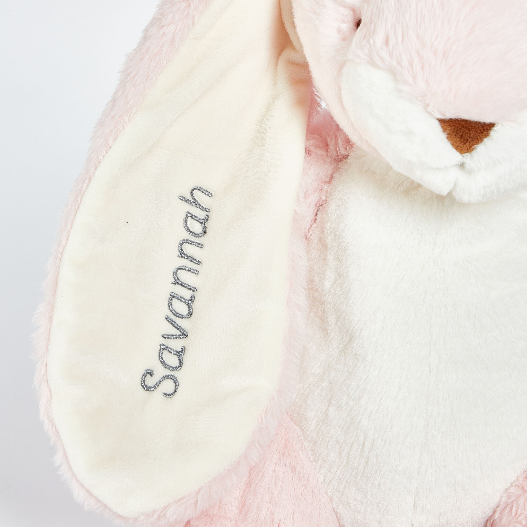 Pink plush toy with 'Savannah' embroidered on it against a white background