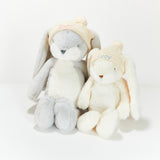 Two plush toys, one gray and one white, with bunny ears on a white background.