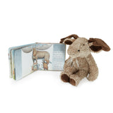 Stuffed animal next to a children's book on a white background