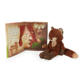 Stuffed fox toy next to an open book with a fox illustration on a white background