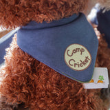 Brown plush fox wearing a blue bandana with 'Camp Cricket' on it.