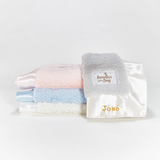 Stack of baby blankets with 'Bunnies by the Bay' branding on a white background
