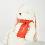 White plush bunny with a red 'Noel' scarf on a light gray background