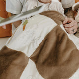 Close up of brown and white fuzzy quilt.