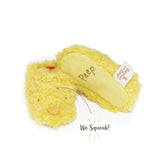 A pair of yellow baby booties with an embroidered 'Peep' on the bottom, featuring a squeaker in the tongue, presented with the text 'We Squeak!'.