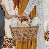 Parent and child holding onto a basket of small plush animals, including bunnies, a chick and a lamb.