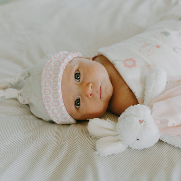 Newborn baby girl swaddled in a pink blanket