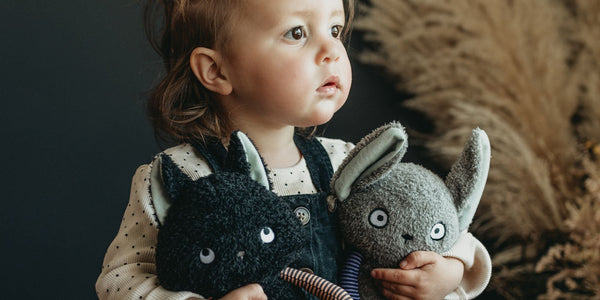 Little Girl holding 2 stuffed animals