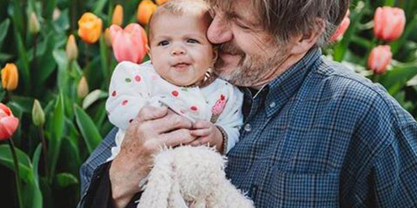 Grandparent holding a baby in tulip fields