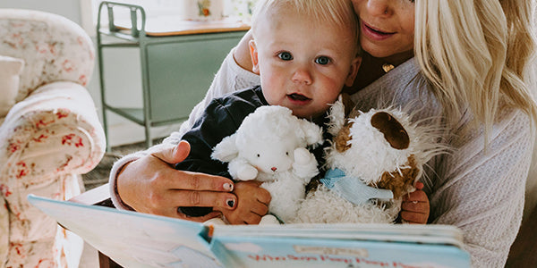 Little boy holding 2 plush animals