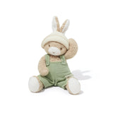 Stuffed toy rabbit wearing a green outfit on a white background