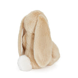 Beige bunny with white pom-pom tail on a white background
