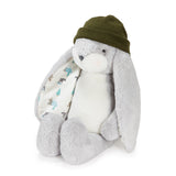 A plush bunny toy with long floppy ears, a white body, gray feet and inner ears, wearing an olive green knit hat. It has patterned inner ears.