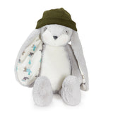 A plush stuffed bunny toy in light gray and white, wearing an olive green knit hat, photographed on a clean white background.
