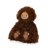 A brown furry plush toy shaped like a bigfoot or sasquatch, with a stitched tan face and paw pads, photographed on a clean white background.