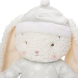 Plush toy rabbit wearing a white hat and coat on a light background