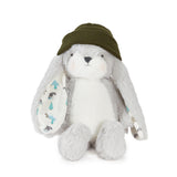 A plush stuffed bunny toy in white and light gray, wearing an olive green knit hat with patterned inner ears, photographed on a clean white background.