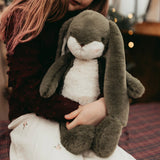 Person holding a large plush rabbit toy with blurred background