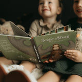 Children reading a book titled 'Smidgen & Bruce' about a big friendship.