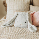 Plush rabbit toy on a textured surface with soft background