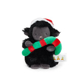 Black plush lamb toy with a Santa hat and Christmas candycane on a white background