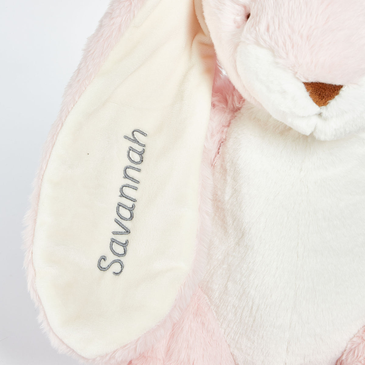 Pink plush toy with 'Savannah' embroidered on it against a white background