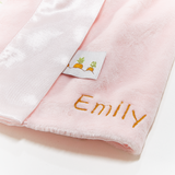 Pink fabric with 'Emily' embroidered on it and a small label with carrot designs.