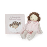 Stuffed doll in a pink dress with a book titled 'A Pretty Girl Is Pretty Inside' on a white background