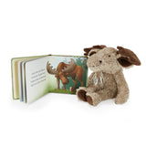 Plush animal toy next to an open book with illustrations on a white background