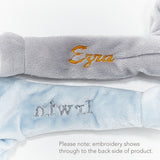 Sample embroideries on soft gray and blue lovies.