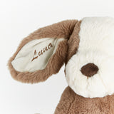 Close-up of a plush stuffed animal head with long brown faux-fur trim, a white plush face, a brown nose, and the name 'Lena' embroidered in brown on the inner ear, against a plain white background.