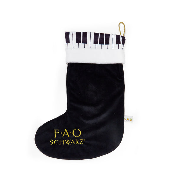 Black Christmas stocking with piano patterned cuff and FAO Schwarz logo on a white background