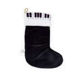 Black Christmas stocking with FAO Schwartz piano key pattern on a white background