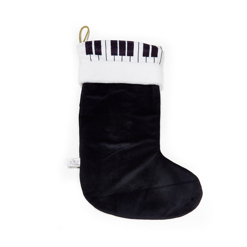 Black Christmas stocking with FAO Schwartz piano key pattern on a white background