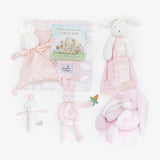 Baby gift set with pink plush toys and a book on a white background