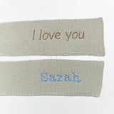 Two knit scarves with personalized embroidery text on a white background