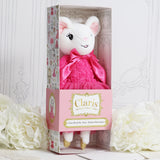 A plush mouse doll in a pink dress displayed inside an ornate pink gift box. The box has decorative floral and damask patterns, and the front label reads 'Claris'.