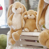 Two plush bunny toys sitting on a white surface with a blurred background