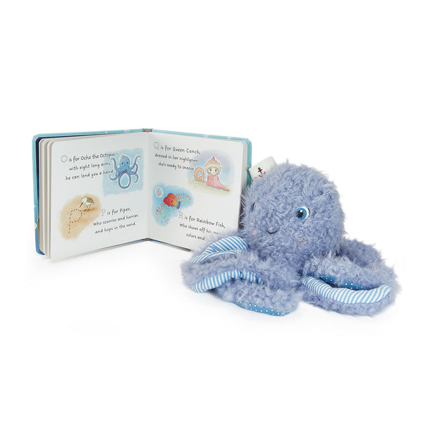 Plush octopus toy next to an open book on a white background