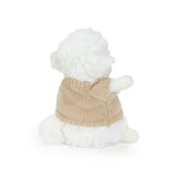 Small plush toy resembling a lamb wearing a beige knitted sweater on a white background